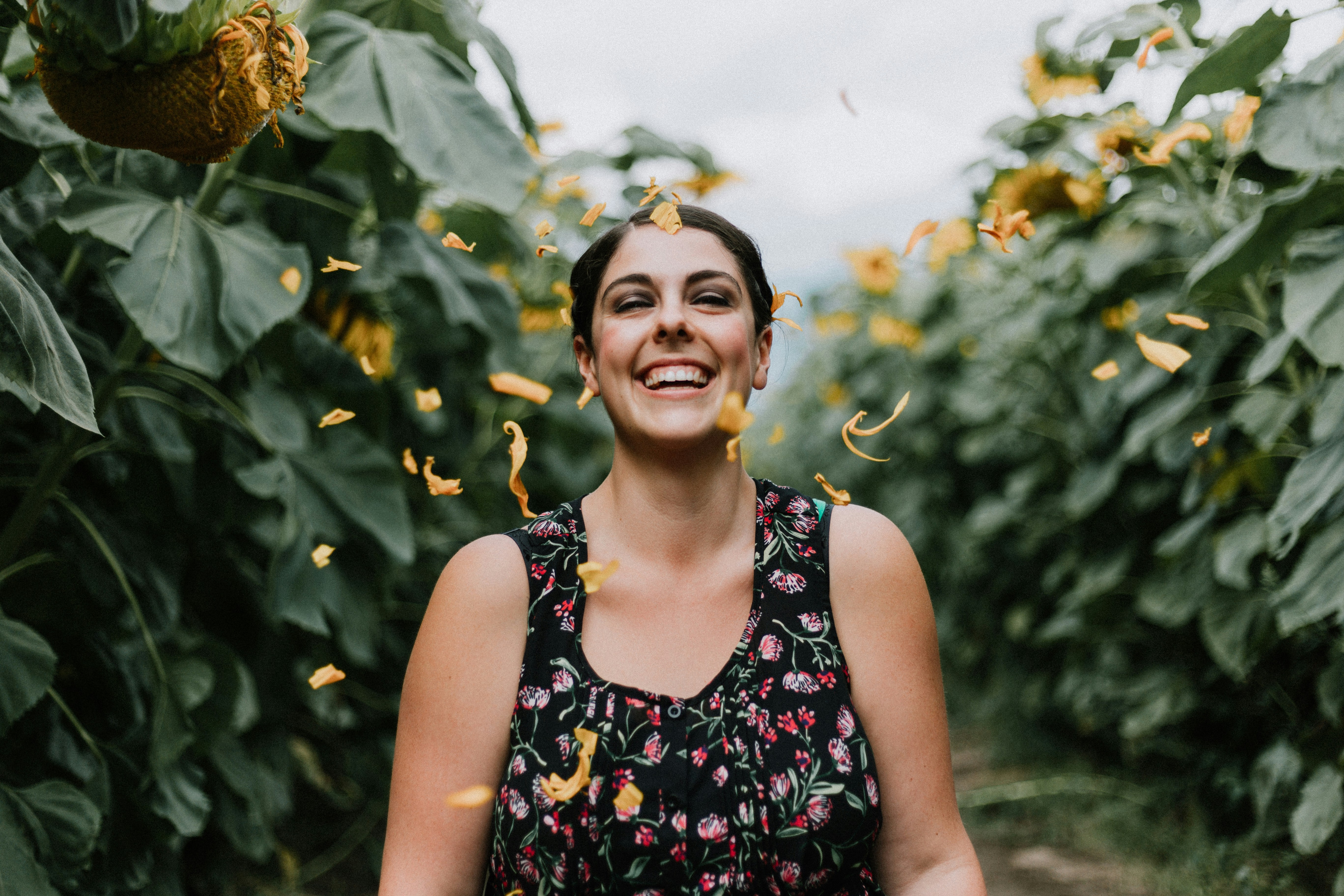 Woman laughing in sunflowers, feeling free from anxiety